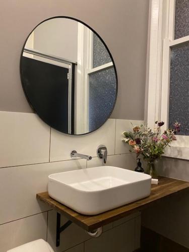 ein Badezimmer mit einem weißen Waschbecken und einem Spiegel in der Unterkunft The Barkly Bistro Bar & Accommodation in Ararat