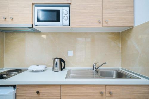 a kitchen with a sink and a microwave at Mikres Kyklades in Skala Potamias