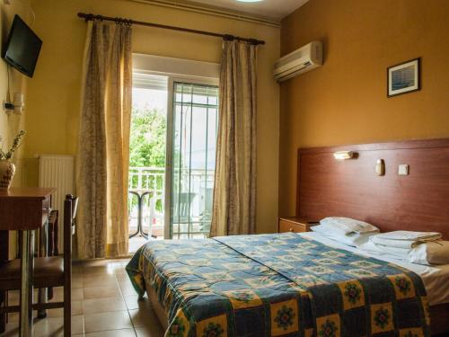 a hotel room with a bed and a balcony at Villa Theodora in Fanárion