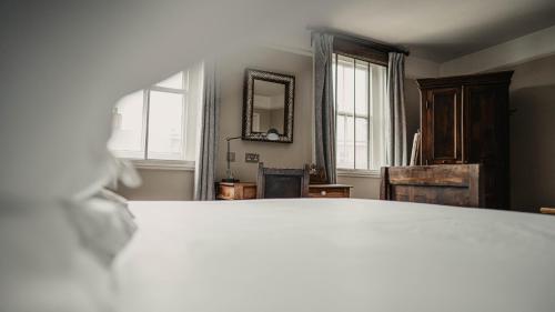 a bedroom with a bed and a dresser at Elephant Hotel in Pangbourne
