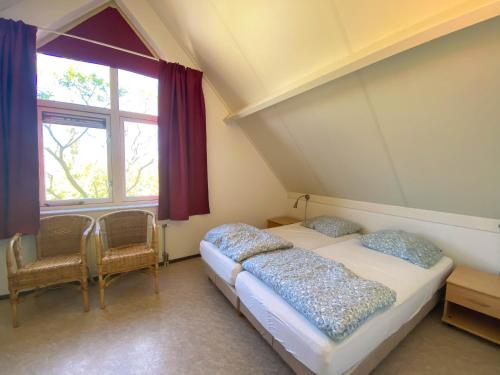two twin beds in a room with a window at Hello Zeeland - Vakantiehuis Zwin 015 in Breskens