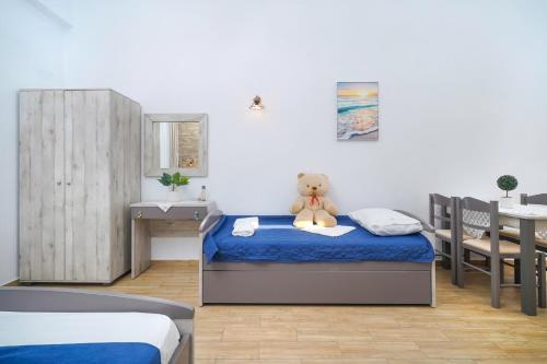 a teddy bear sitting on a bed in a bedroom at Mikres Kyklades in Skala Potamias