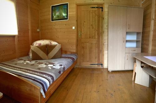 a room with a bed in a wooden cabin at Kazikówka - Domki letniskowe w Solinie in Solina