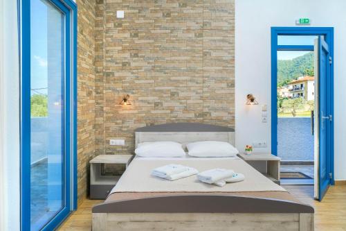 a bedroom with a bed and a brick wall at Mikres Kyklades in Skala Potamias