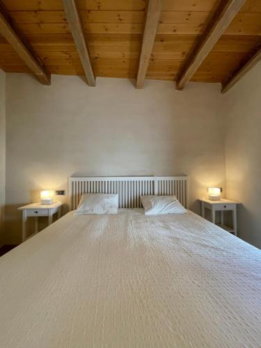 a bedroom with a large white bed with two lamps at APARTAMENTOS RURALES POSADA DE LLERENA in Llerena