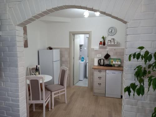 Una cocina con una mesa y un refrigerador blanco. en Old marine house, en Tivat