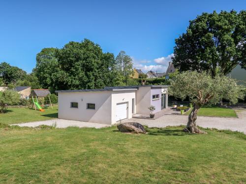 ein kleines weißes Gebäude in einem Hof mit einem Baum in der Unterkunft Holiday Home Penn Sardin - DNZ100 by Interhome in Douarnenez