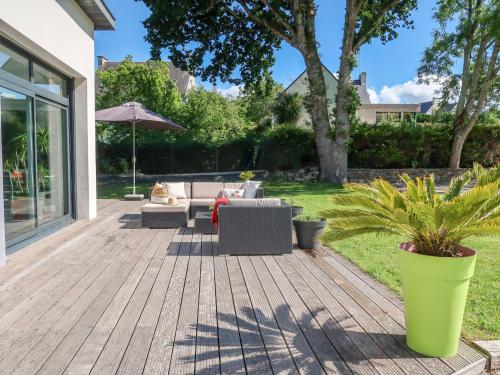 eine Terrasse mit Gartenmöbeln und einem Sonnenschirm im Hof in der Unterkunft Holiday Home Penn Sardin - DNZ100 by Interhome in Douarnenez