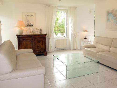 un salon avec un canapé et une table basse en verre dans l'établissement Holiday Home La Marinière by Interhome, à Trégunc