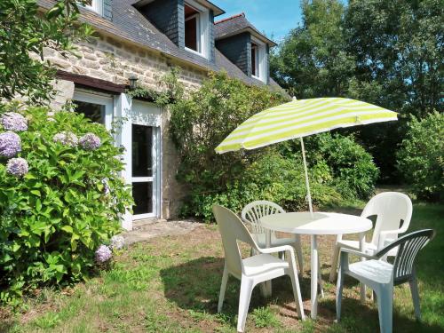 einen Tisch und Stühle mit Sonnenschirm im Hof in der Unterkunft Holiday Home La Ferme Bis by Interhome in Loctudy