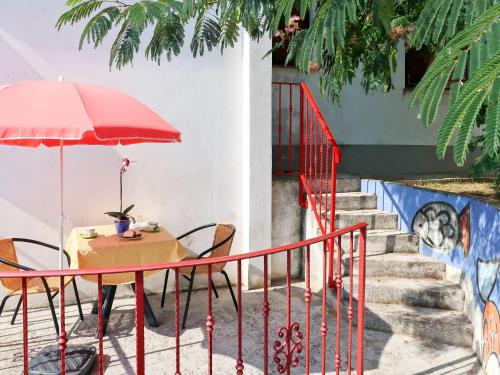 a table with a red umbrella and chairs and stairs at Apartment Adalgisa - LBN128 by Interhome in Labin