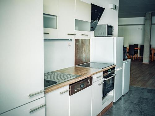 a kitchen with white cabinets and a white refrigerator at Casa Granula in Bad Ragaz