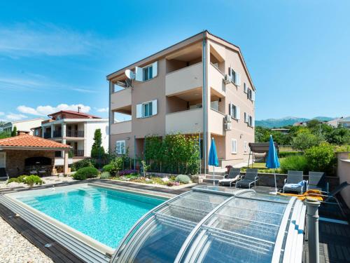 a swimming pool in front of a building at Apartment Matas-4 by Interhome in Rovanjska