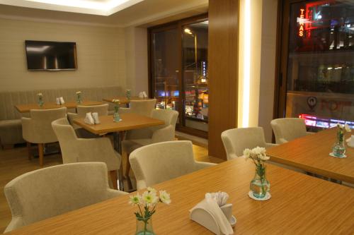 a restaurant with wooden tables and chairs with flowers on them at Besiktas Otel in Istanbul