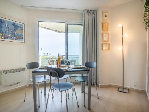 comedor con mesa, sillas y ventana en Apartment Gulf Stream by Interhome, en Biarritz
