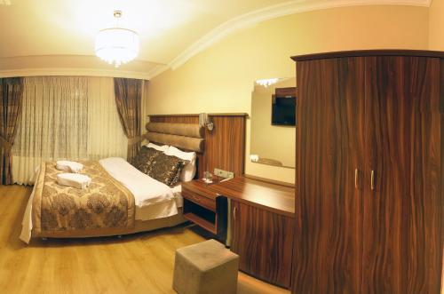 a bedroom with a bed and a large wooden cabinet at Besiktas Otel in Istanbul