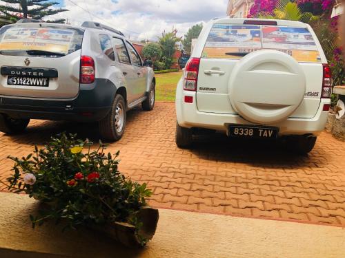 two cars parked next to each other on a brick driveway at Petite Flower Guest House in Talata-maty
