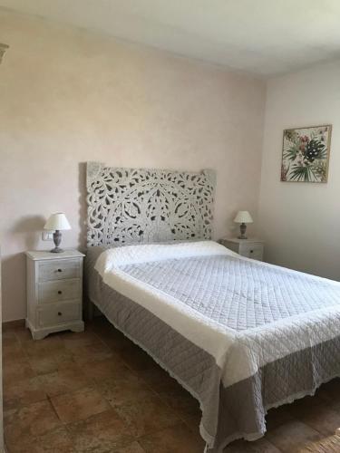 a bedroom with a white bed and two night stands at Casa Il Girasole in Marina di Grosseto