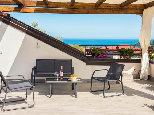 un patio con sillas y una mesa con vistas al océano en Holiday Home Luppinedda by Interhome, en Mascali