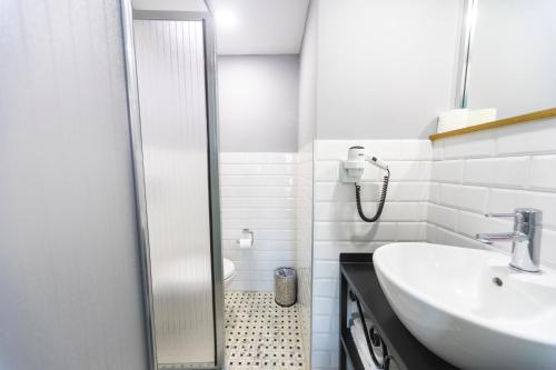 een witte badkamer met een wastafel en een douche bij Istanbul Box Hotel in Istanbul