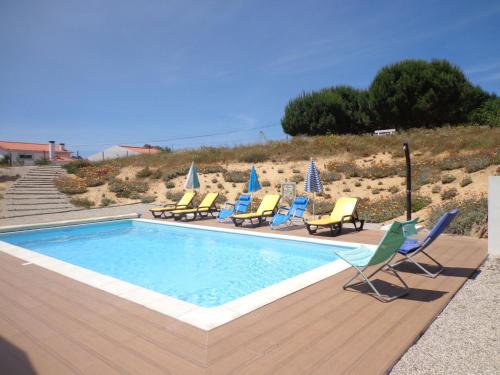 a swimming pool with lounge chairs and a bunch at Holiday Home Do Pinheiros by Interhome in Vau