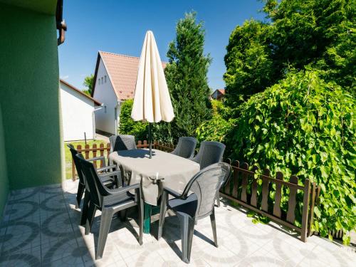 une terrasse avec une table, des chaises et un parasol dans l'établissement Holiday Home Verde by Interhome, à Balatonlelle