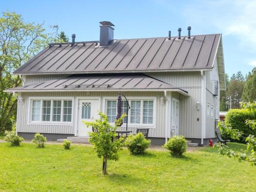 una casa blanca con techo de metal en Holiday Home Villa einola by Interhome, en Nilsiä