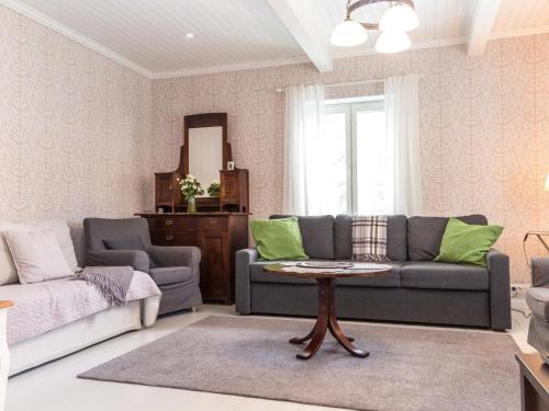 a living room with a couch and a table at Holiday Home Villa einola by Interhome in Nilsiä