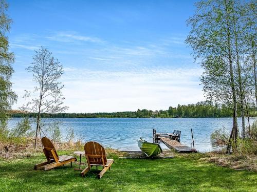 dos sillas y una mesa y un barco en un lago en Holiday Home Koivuranta by Interhome, en Räätäniemi