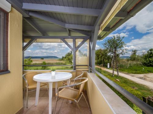 un patio con tavolo e sedie bianchi sul balcone. di Apartment Katie 1 by Interhome a Balatonmáriafürdő