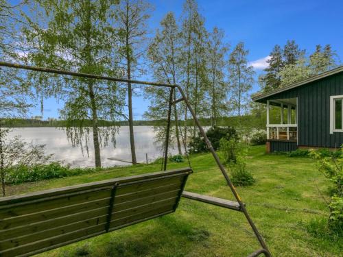 a swing in a yard next to a house at Holiday Home Rantapelto by Interhome in Heinälahti