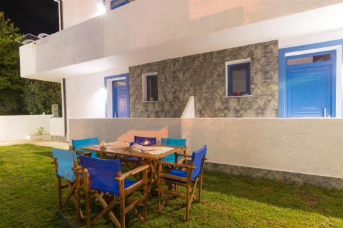 a wooden table and chairs in the backyard of a house at Mikres Kyklades in Skala Potamias