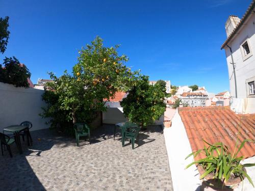 Castelo Terrace في لشبونة: فناء به كراسي وأشجار برتقال وسقف