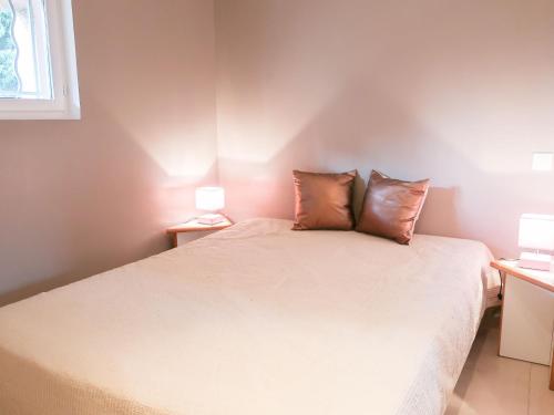 une chambre avec un lit avec deux oreillers dessus dans l'établissement Apartment Les Deux voiles-1 by Interhome, à La Foux