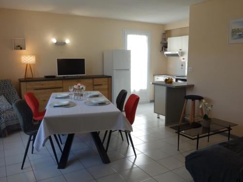 een woonkamer met een tafel met stoelen en een keuken bij Apartment Les Jardins de l'Eden by Interhome in Pontaillac
