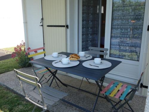 een blauwe tafel en stoelen op een veranda bij Apartment Les Jardins de l'Eden by Interhome in Pontaillac