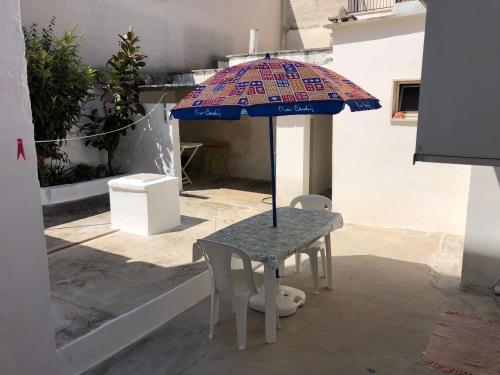 uma mesa com um guarda-chuva num pátio em Casavacanza David em San Michele Salentino