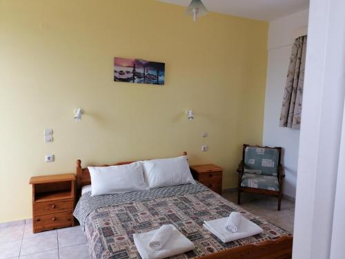 a bedroom with a bed with two towels on it at Andreas Apartments in Kefalos