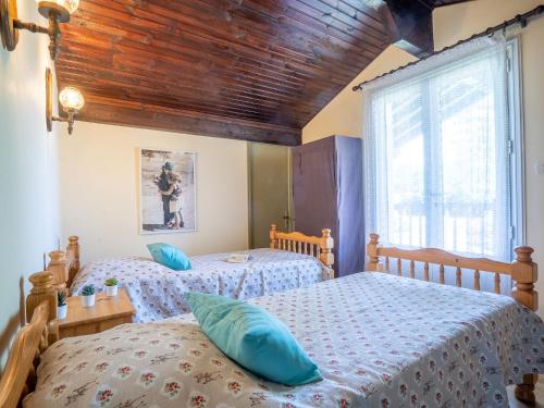 two twin beds in a bedroom with a wooden ceiling at Holiday Home Geroko by Interhome in Arcangues