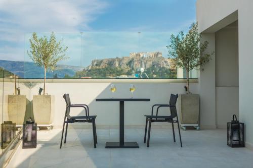 a table and chairs with a view of the acropolis at Ivis 4 Boutique Hotel in Athens