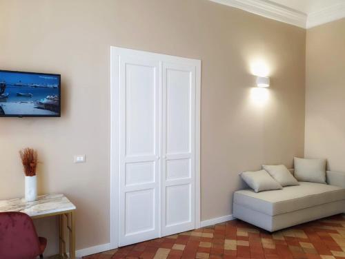 a room with a white door and a white couch at Palazzo La Piana Rooms in Catania