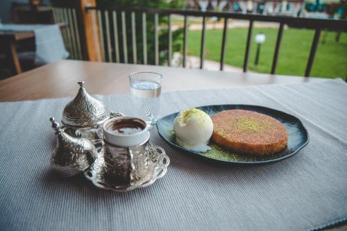 a table with a plate of cake and a cup of coffee at SPA Kompleks Raiski Kat in Dimitrovgrad