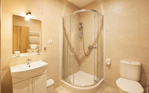 a bathroom with a shower and a toilet and a sink at ROYAL M in Sabinov