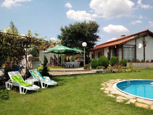 een tuin met stoelen en een zwembad en een huis bij Къща за гости Симона яз.Тича in Sushina