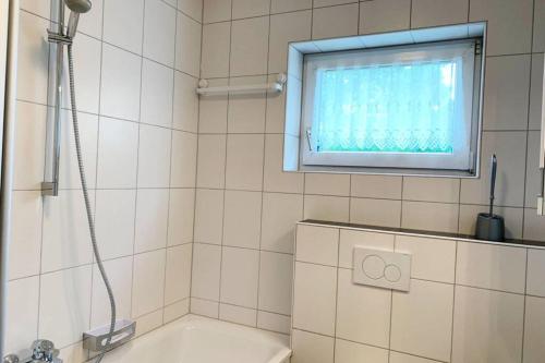 baño con ducha y bañera y ventana en Gemütliche Wohnung in Siegen en Siegen
