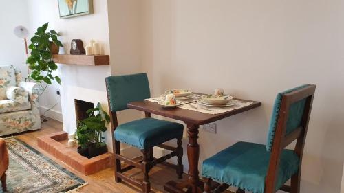 a dining room table with two chairs and a table with dishes on it at Argyll House Bed and Breakfast in Westleton