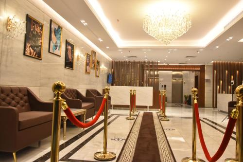 a lobby with red rope barriers and a chandelier at درة العروس للوحدات السكنية المفروشة in Jeddah