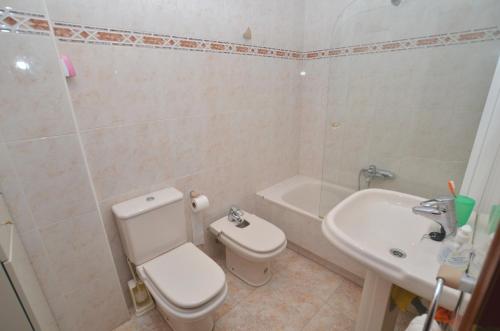 a white bathroom with a toilet and a sink at Residencial Cilla - 6022 in Noja
