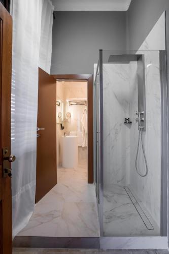 a bathroom with a shower with a glass door at The Rif - Boutique Hotel in Pisa