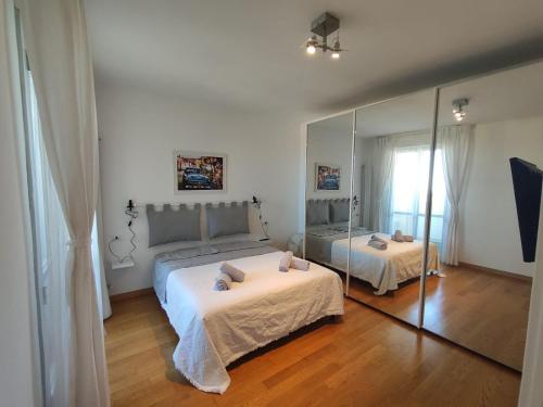 sypialnia z 2 łóżkami i dużym lustrem w obiekcie CasaBelvedere Vista Mare e Comfort w mieście Pescara